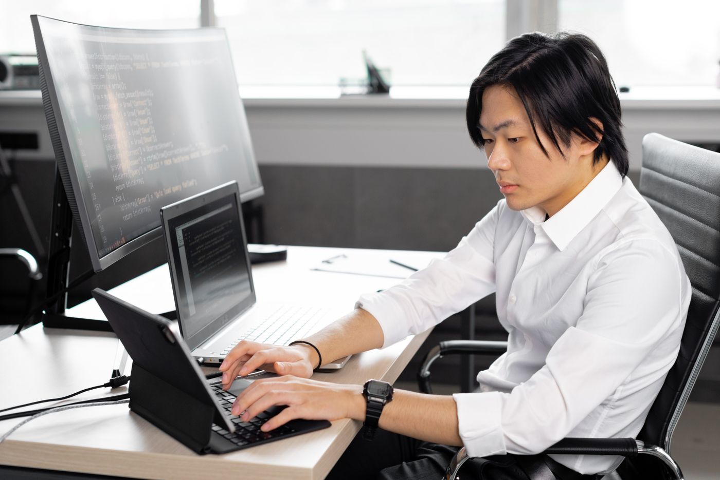 An engineer working at a laptop and a monitor