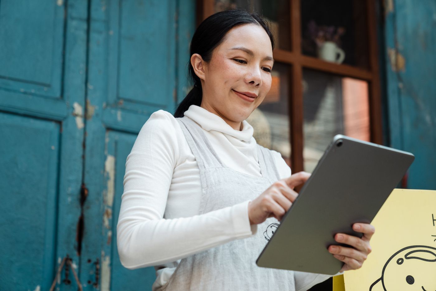 A stall owner using a tablet outside a shop